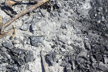 Gray ash on the ground from a fire in nature, coal, gray ash from firewood from a fireplace