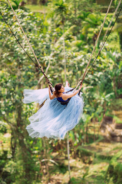 Girl On A Swing. Background Of Rice Terraces. Ubud. Bali. Indonesia