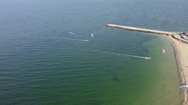 People in sportswear on kiteboards ride on the Black Sea in Bulgaria