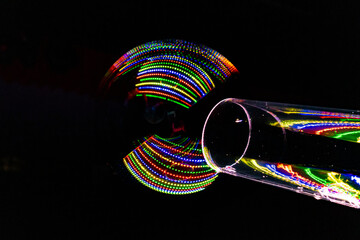 colored lights reflected in soap bubble created through a transparent tube