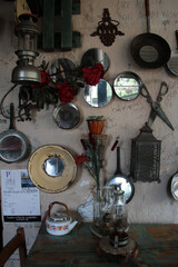 Fototapeta na wymiar A photo of a bunch of old stuff on a wall. Dishes, kettle, pans, scissors.
