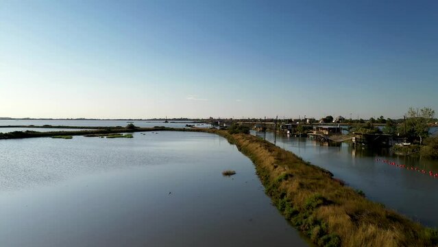 Aerial view of fishing lodges mounted on poles in the water, Comacchio Lagoon On Sunset, Northern Italy