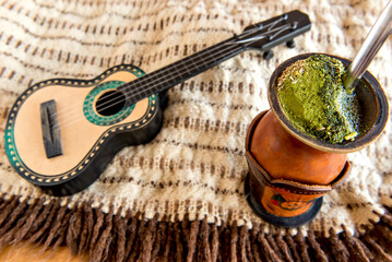 Gaucho tradition, poncho, guitar and chimarrao of yerba mate tea.