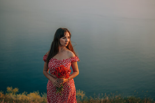 portrait young woman in summer backdrop sea with bouquet of flowers