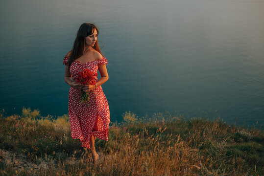 portrait young woman in summer backdrop sea with bouquet flowers