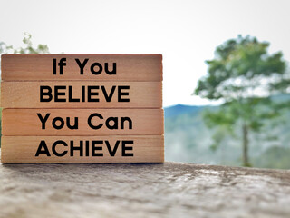 If you believe you can achieve text on wooden blocks with nature background. Inspirational and motivational concept.