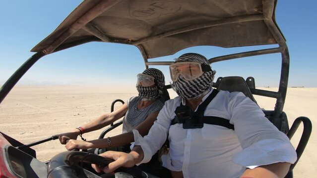 EDITORIAL GO PRO???? Young adventure couple on a safari trip, driving a buggy in the desert - main tourist attractiion in Egypt