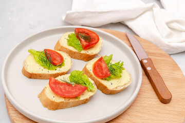 Bruschetta sandwich bread toast with soft white cheese ricotta,fresh tomatoes,basil greenery on a wooden cutting board.Tasty healthy vegetarian food,Italian cuisine appetizer. top view flat lay