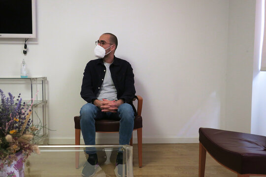 Young man wearing facemask in dentist waiting room