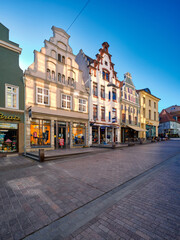 Old historic buildings, houses in Wismar, Germany. Empty square early morning. Sunny day with blue...