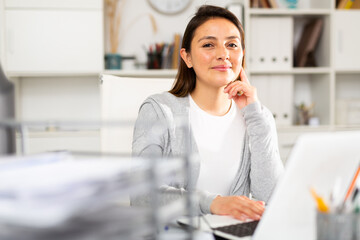 Portrait of woman working on laptop in office