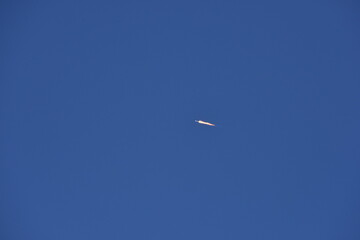 Distant Rocket Launch clear Blue Day with exhaust trail and sunny sky
