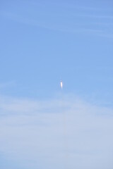 Distant Rocket Launch clear Blue Day with exhaust trail and sunny sky
