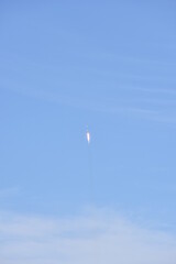 Distant Rocket Launch clear Blue Day with exhaust trail and sunny sky