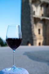 Glass of red dry wine and ruins of medieval castle of Châteauneuf-du-Pape ancient wine making village in France