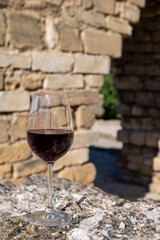 Glass of red dry wine and ruins of medieval castle of Châteauneuf-du-Pape ancient wine making village in France