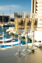 Three glasses of French champagne sparkling wine and view on colorful fisherman's boats in old harbour in Cassis, Provence, France
