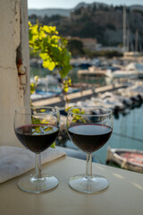 Drinking of red wine on outdoor terrace with view on old fisherman's harbour with colourful boats in Cassis, Provence, France