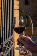 Tasting of red wine by old wine maker in Pierres Dorées region with yellow stone houses on south of Beaujolais region, France