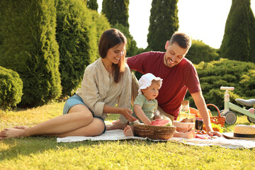 Happy family having picnic in garden on sunny day