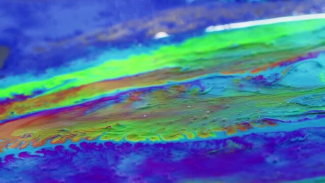 Painting relax. Fluid magic. Creative art. Light green liquid stream of paint floating and mixing together with glittered violet in macro shooting.