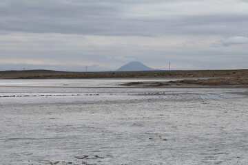 Vista de una salina, con una montaña en el fondo .