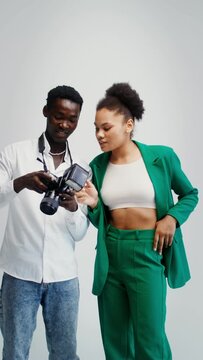 Photographer and model select photos taken in studio vertical video