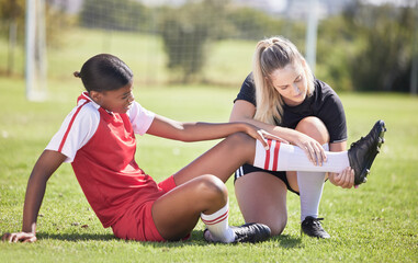 Soccer, sports and injury of a female player suffering with sore leg, foot or ankle on the field. Painful, hurt and discomfort woman getting her pain checked out by athletic trainer on the pitch. - Powered by Adobe