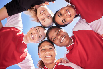 Female soccer team huddle bonding, smiling or motivated in circle with heads in middle. Below portrait of fit, active and diverse group of football girls, friends or athletes at sports, match or game - Powered by Adobe