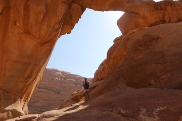 Hombre de viaje viendo al horizonte enmarcado por una roca