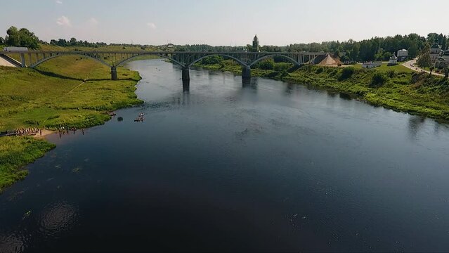 Shooting from a drone of a river and a bridge over it in good summer weather. Wonderful shots of a small town