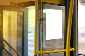 Open bus door entrance with yellow handrail and copy space empty poster on a window....