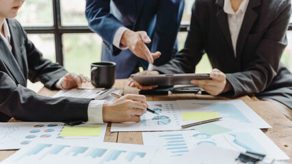 Close-up of businessman and woman explaining a financial plan to colleagues at meeting.