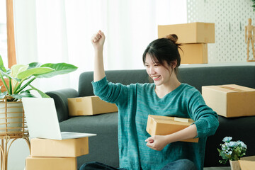 Obraz na płótnie Canvas Young happy asian SME business woman use digital checking customer order.