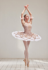 Female ballerina doing ballet dance, dancing or performing during a practice rehearsal in studio. Young dancer or artist in a tutu costume dress and shoes doing pointe technique on toes performance - obrazy, fototapety, plakaty