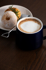 hot coffee with donuts on wooden table