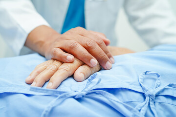 Doctor holding hands Asian elderly woman patient, help and care in hospital.