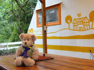 The toy sits on a dining table outdoors with a wall with yellow graffiti in the background