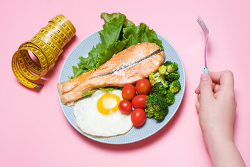 Plate with balanced food and female hand. Concept of keto diet and healthy nutrition.