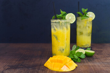 Mango mojito in highball glass with sliced mango isolated on wooden table