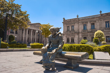 San Luis Potosi, San Luis Potosi, Mexico, 07 26 22, Statue of a man sitting with a girl in front of the theater of La Paz in Plaza del Carmen, the historic center of the city