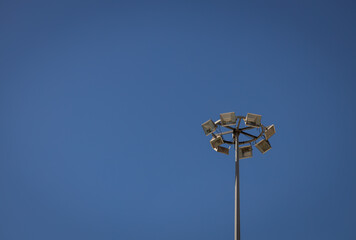 Lighting tower of several lamps. Upward view on a sunny day.
