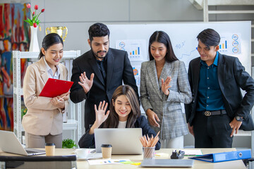 Asian business team male and female colleagues use laptop for video call meeting online.
