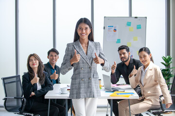 Portrait of Asian beautiful business woman working at the office, beautiful woman with thumb up at her working place.