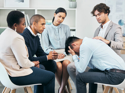 Depression, Support And Unity By Colleagues Comforting Male After Getting Bad News At Work. Community Care From Workers Sitting Together, Supporting Their Friend After Being Fired Or Through Grief