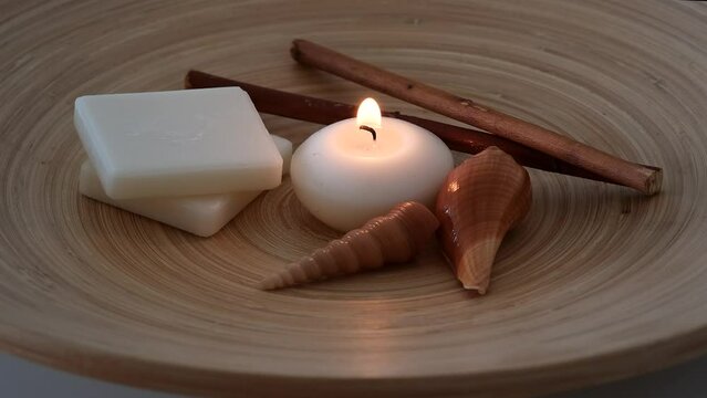 spa concept - burning candle with soap, seashells