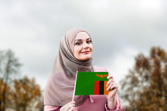 Muslim Woman In Hijab Holds Flag Of Zambia
