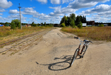 The bike is parked on a rural street on a summer day