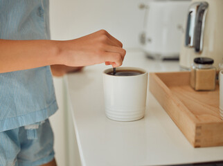 Making fresh, hot morning coffee indoors on a kitchen counter to start the day. Hand closeup of...