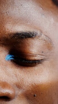 Close-up of a painted male eye, vertical video